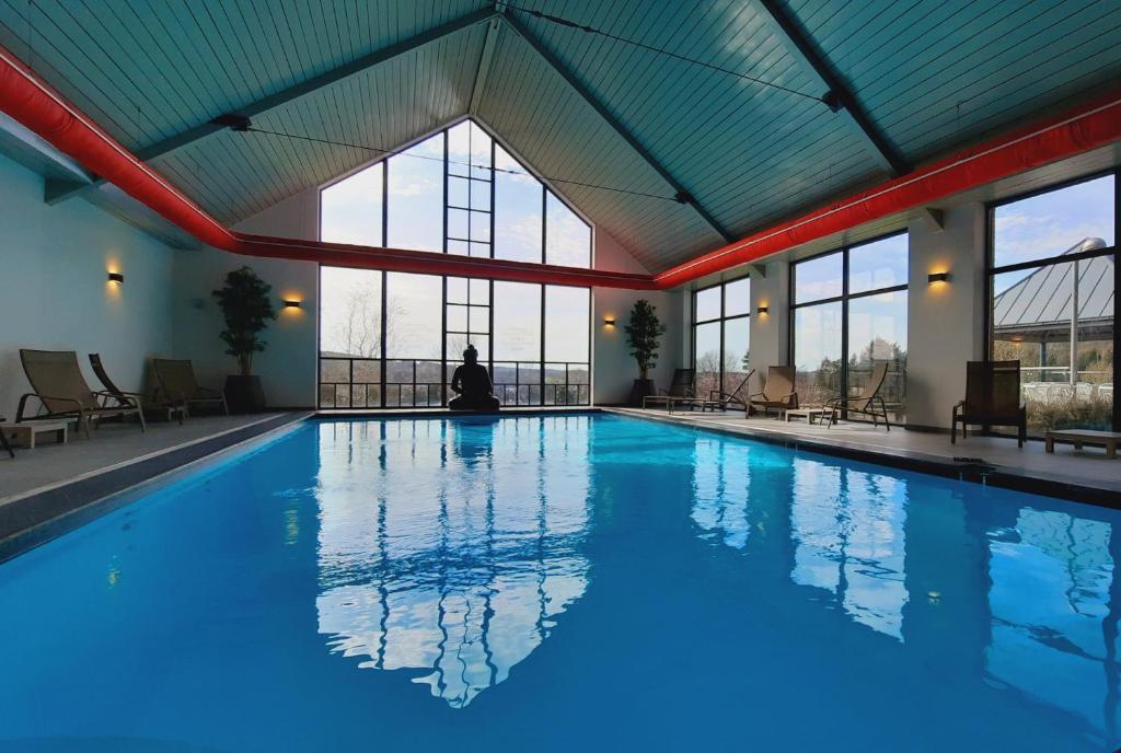 杜柏阿登海岸度假村的坐在建筑物游泳池里的人