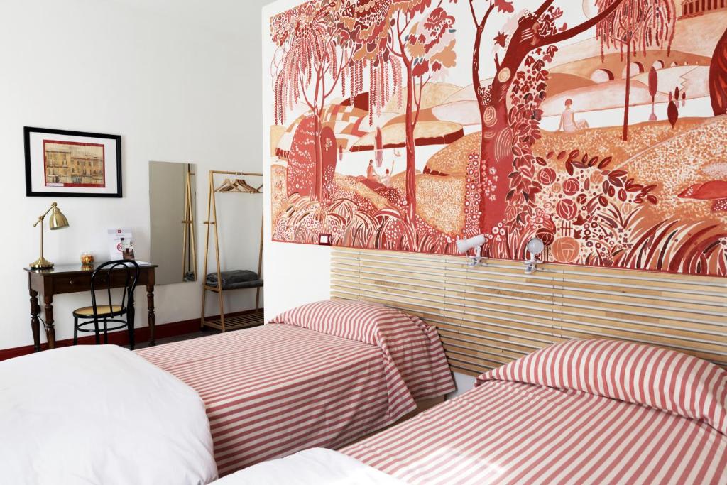 韦尔切利CASABONA1910 bed&breakfast的一间卧室设有两张床,墙上挂着一幅画