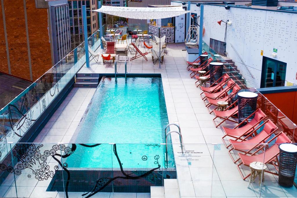 巴塞罗那巴塞罗那市博加特尔宜必思尚品酒店的大楼内一个带桌椅的游泳池