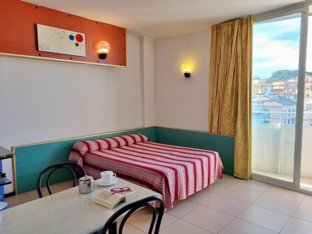 罗列特海岸Apartments Lloret Sun的客房设有两张床、一张桌子和一扇窗户。