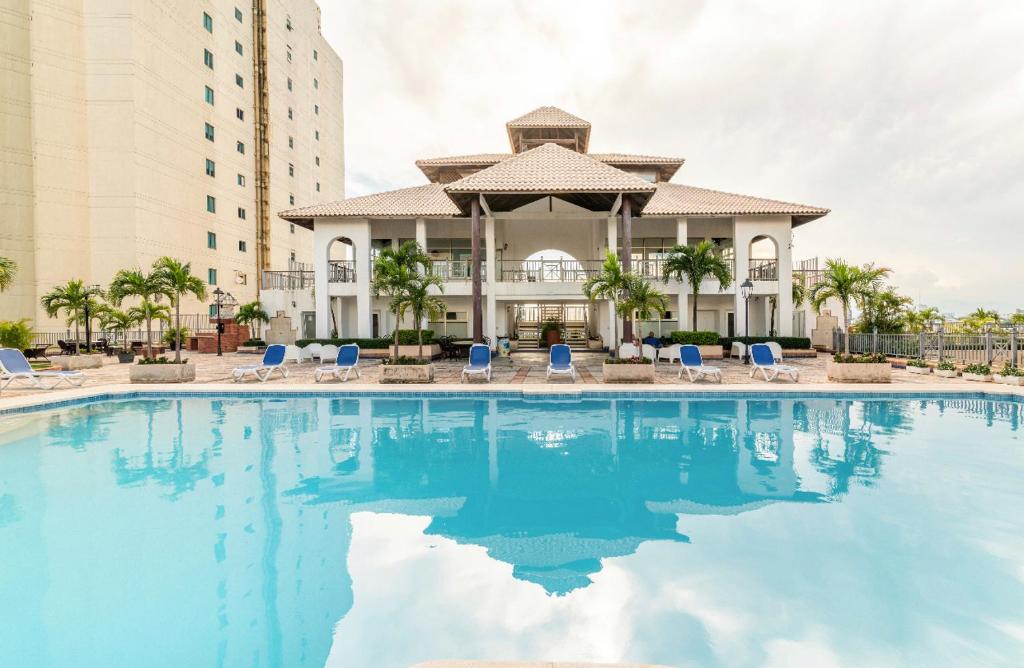 圣多明各Exclusive 3 BDR, Gym & Pool, SeaView, Luxury Tower的一座带蓝色椅子的大型游泳池和一座建筑