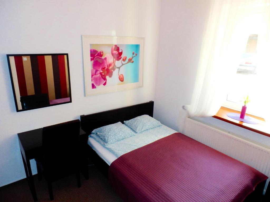 华沙可可旅馆的一间小卧室,配有床和窗户