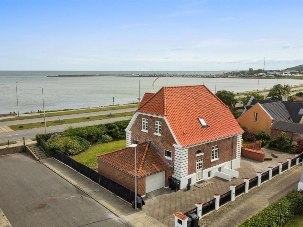 腓特烈港Holiday Home Kosara - 50m from the sea in NE Jutland by Interhome的水边有橙色屋顶的房子
