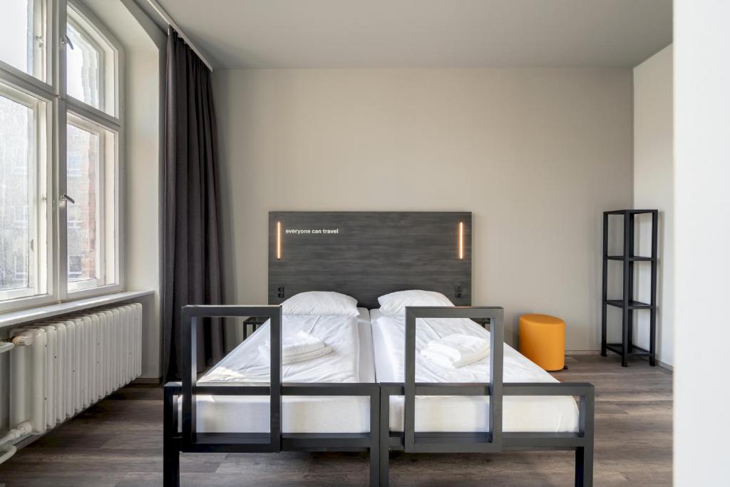 柏林A＆OA&O经济型连锁酒店柏林弗里德里希斯海因店的一间设有床铺的卧室,位于带窗户的房间内
