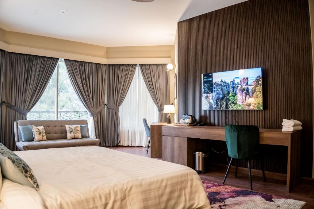伊斯兰堡Hillside Residence E-7 by Paramount Hospitality的配有一张床和一张书桌的酒店客房