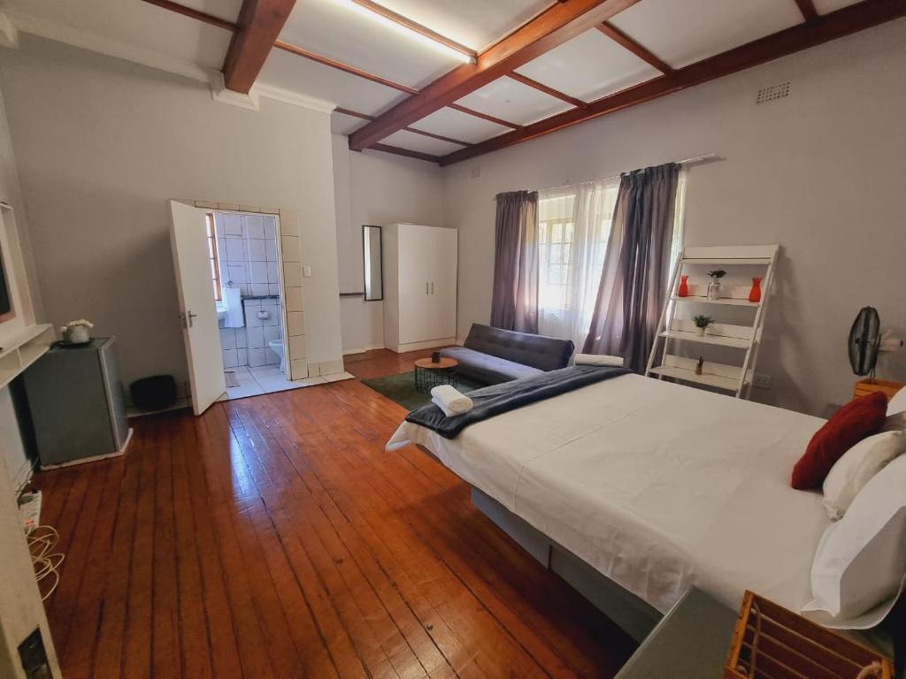 约翰内斯堡Houghton Skye的一间大卧室,配有一张大床和木地板