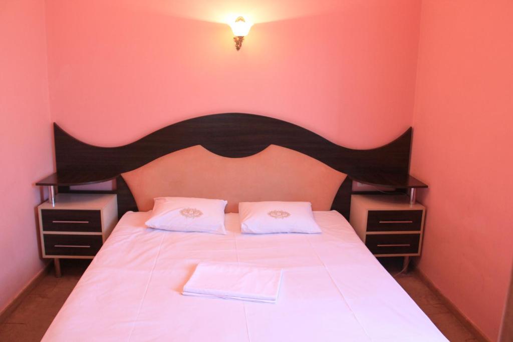 Argavand阿尔贾凡餐厅酒店的一间卧室配有一张带黑色床头板和白色床单的床。