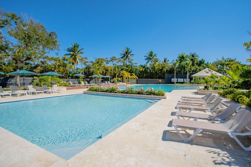 圣斐利-银港Xeliter Green One Playa Dorada的毗邻度假酒店的带躺椅的游泳池