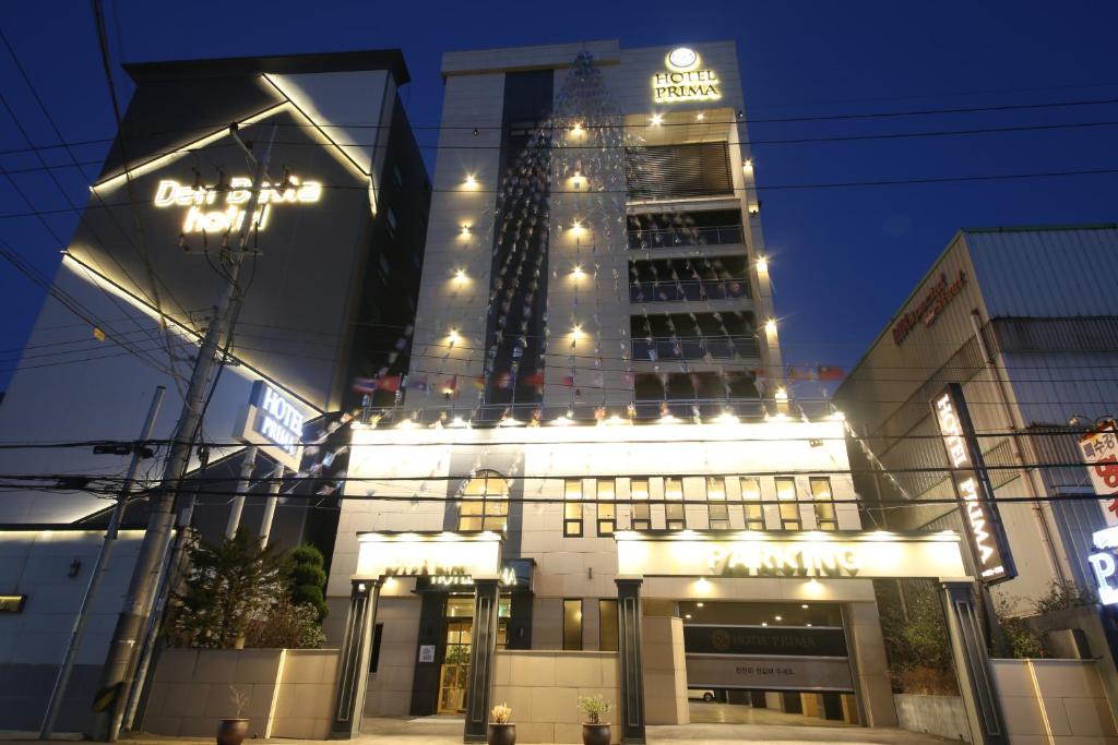 釜山Hotel Prima Busan的一座高大的建筑,晚上有灯