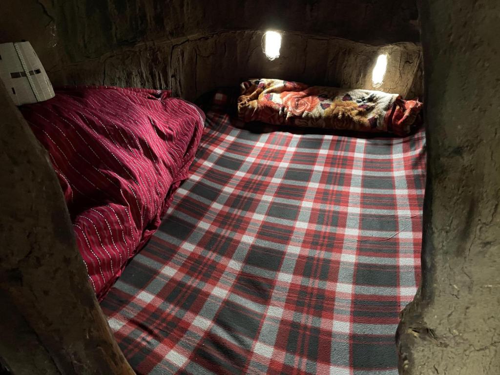 姆托瓦姆布DUPOTO HOMESTAY VILLAGE - MASAI VILLAGE (BOMA)的一张小床,房间带一条铺着地毯的毯子