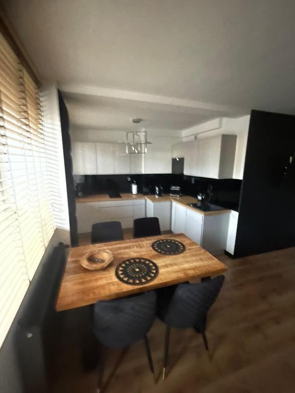 米兹多洛杰Apartament Boho的厨房配有木桌和一些椅子