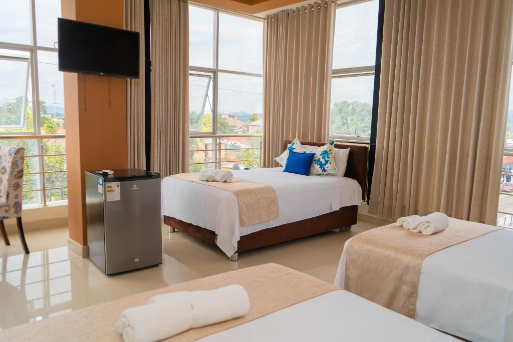 塔拉波托Tropical City的酒店客房设有两张床和一台平面电视。