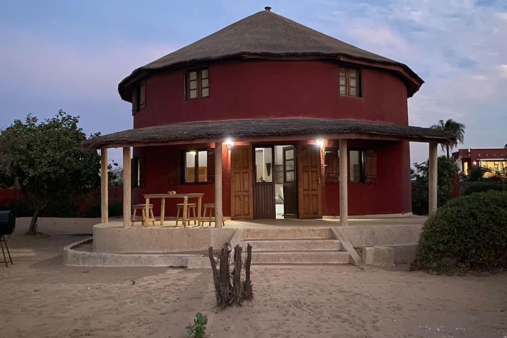 Ngalou SessèneCase beach的前面有一张桌子的红色房子