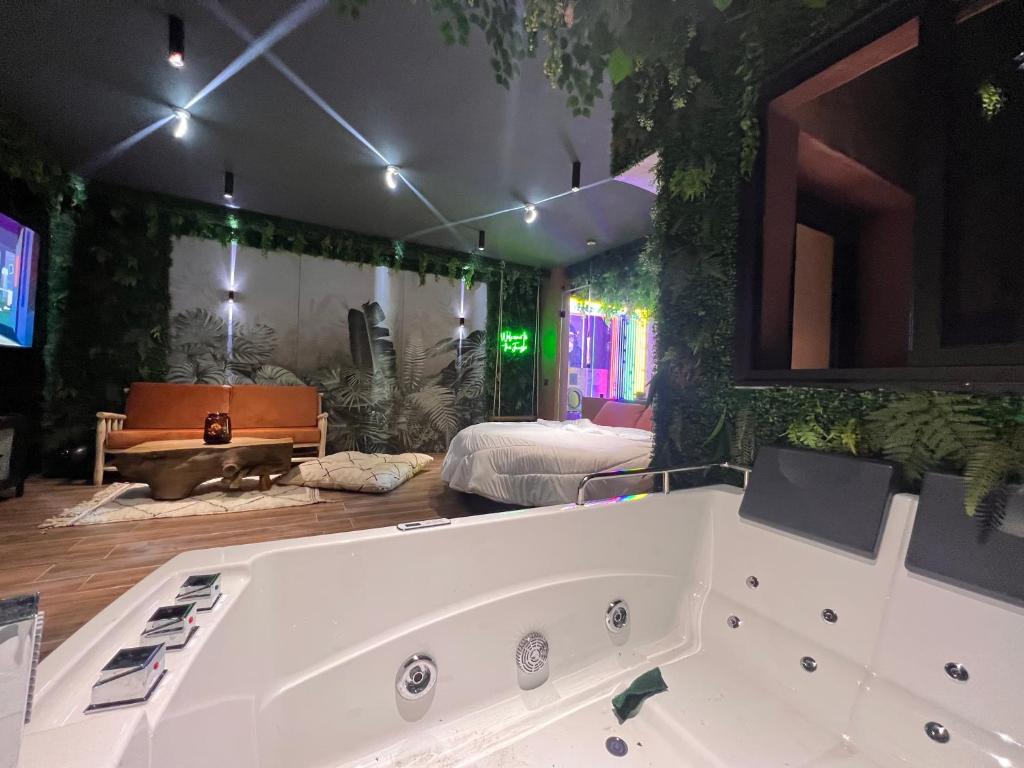 马拉喀什Jungle au centre de marrakech avec Jacuzzi !的配有床的房间的大浴缸