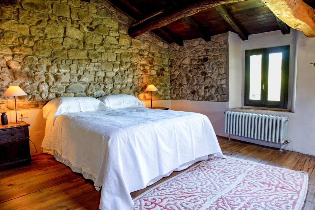 Monte San PietroCa' Lo Spicchio的一间卧室设有两张床和石墙