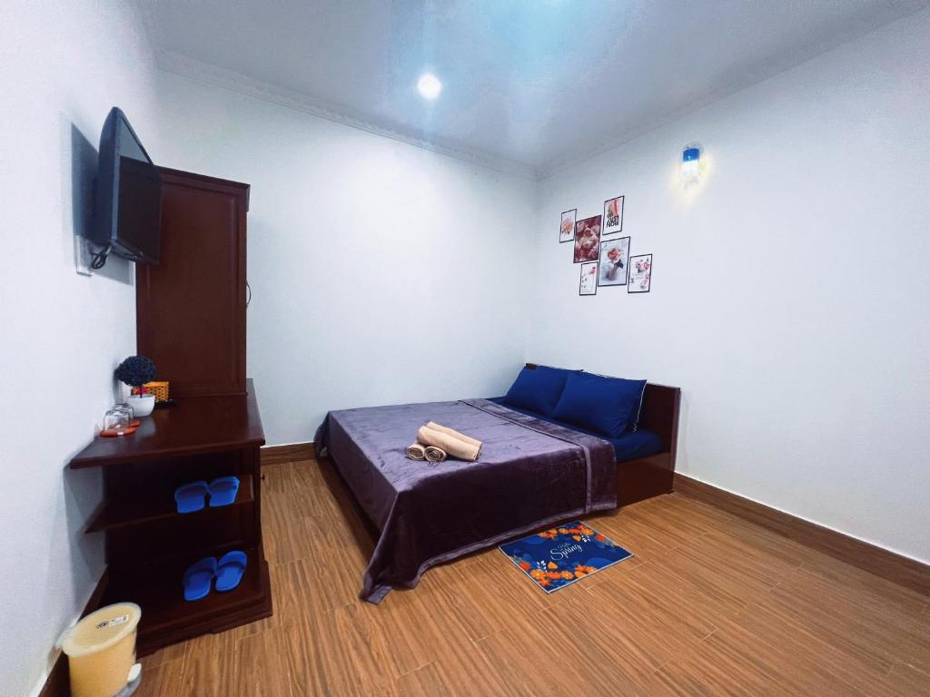 芹苴Nhan Tay Hostel的一间带床和电视的小卧室
