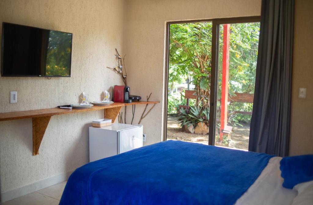 费尔南多 - 迪诺罗尼亚La em casa Noronha的一间卧室设有蓝色的床和滑动玻璃门
