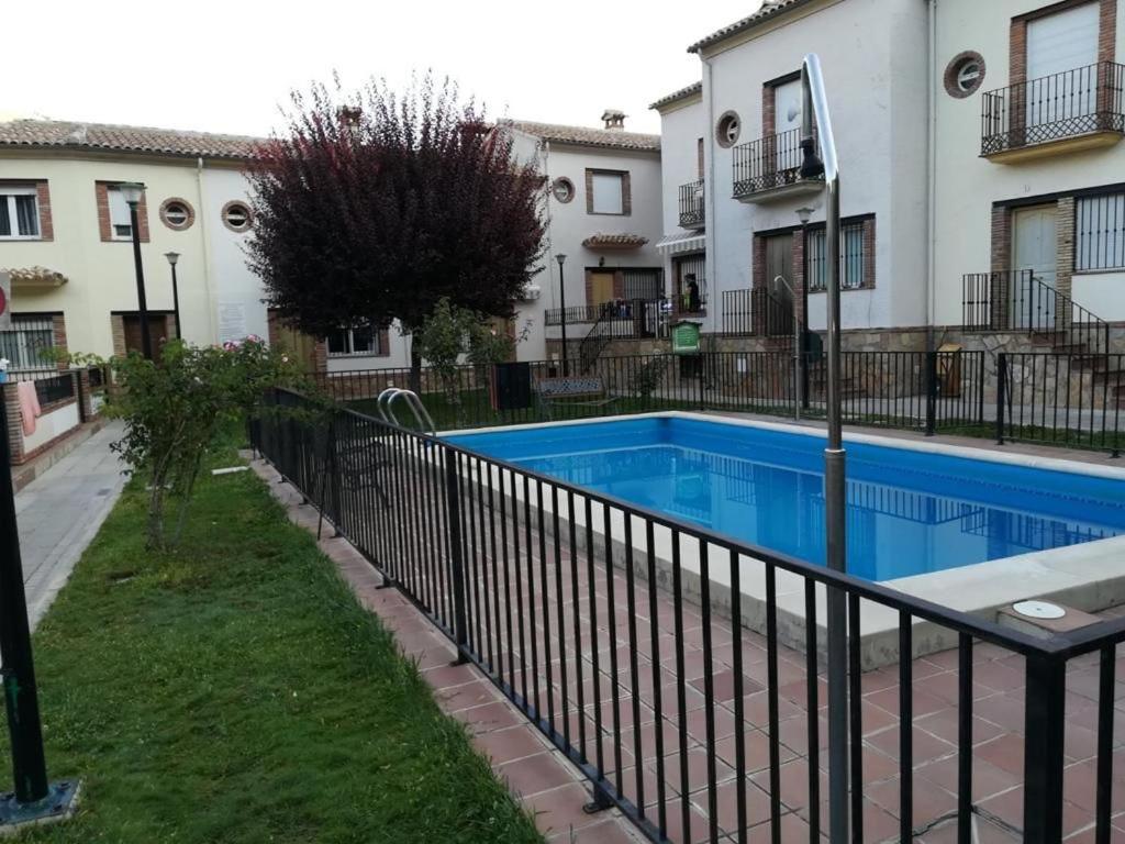 阿罗约弗里奥Casa Miriam II的一座游泳池,旁边是一座建筑,设有围栏