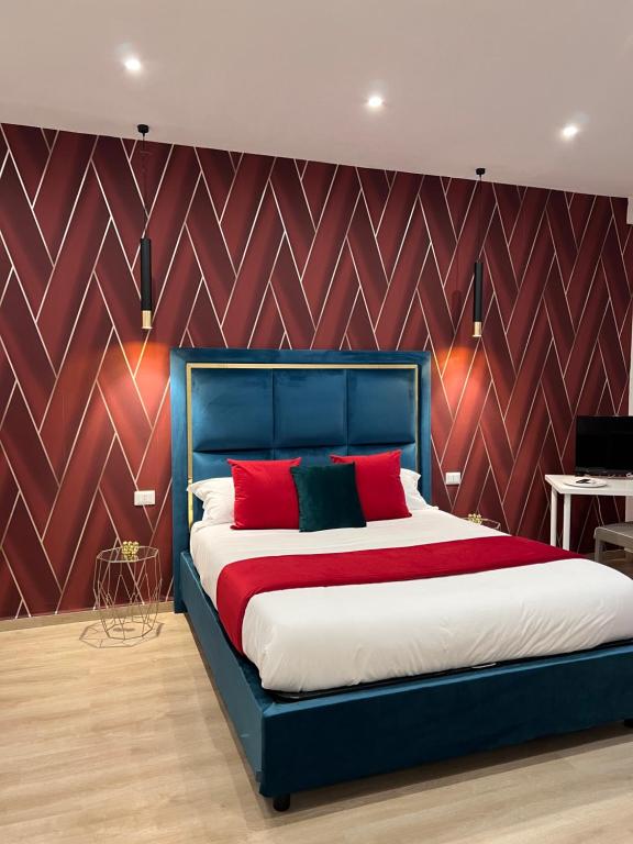 那不勒斯Easy Boarding的一间卧室配有蓝色的床和红色枕头