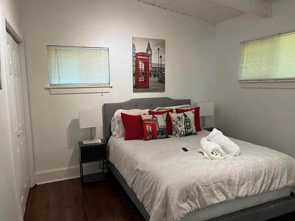亚特兰大Recently renovated Haven in Brookhaven.的一间卧室配有一张带红色枕头的床和电话亭