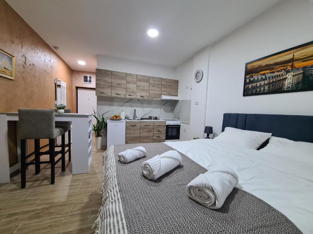 鲁马Stella Apartman Ruma的一间带白色大床的卧室和一间厨房