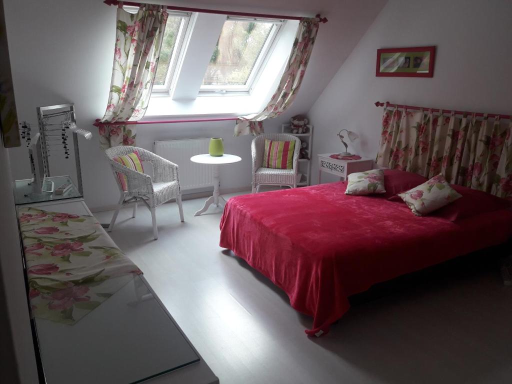 CoulainesChambre d'hôte avec piscine couverte的一间卧室设有红色的床和窗户。