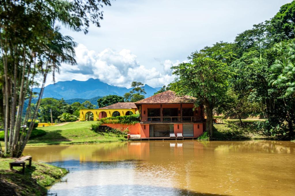 卡舒埃拉斯迪马卡库Hotel Fazenda Filhos do Vento的坐在河顶的房子