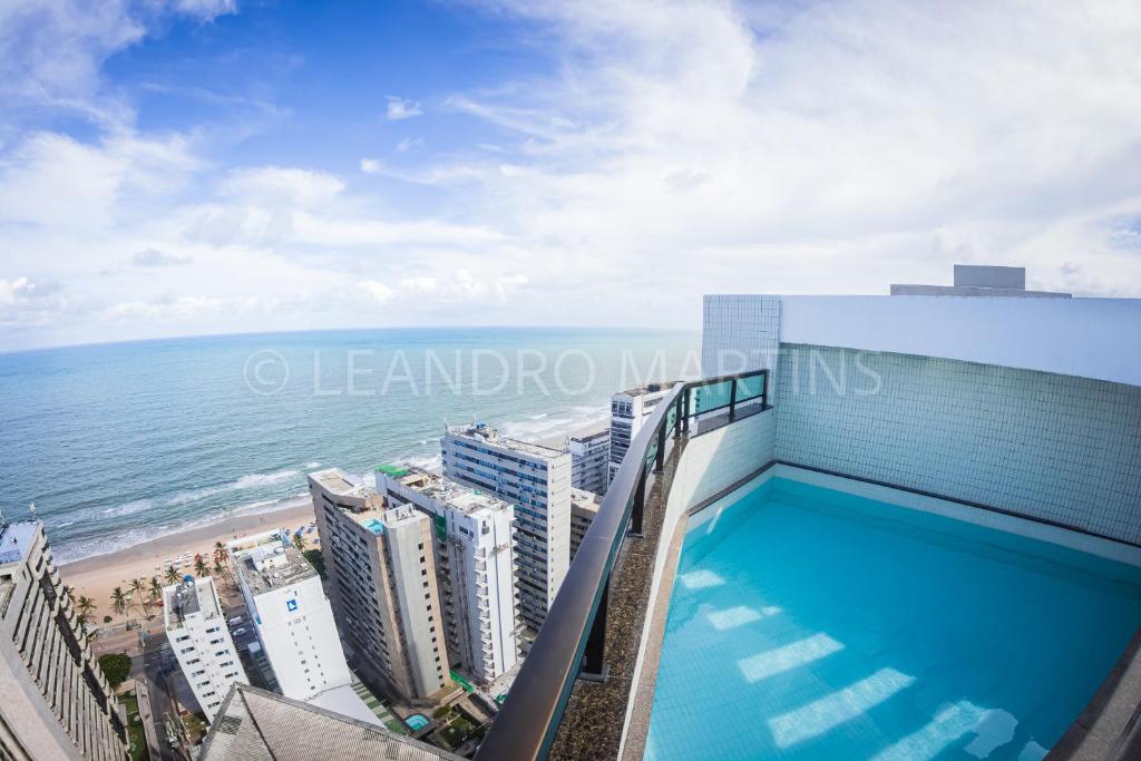 累西腓Apartamento Royale na praia de Boa Viagem的海滩旁一座建筑的顶部游泳池