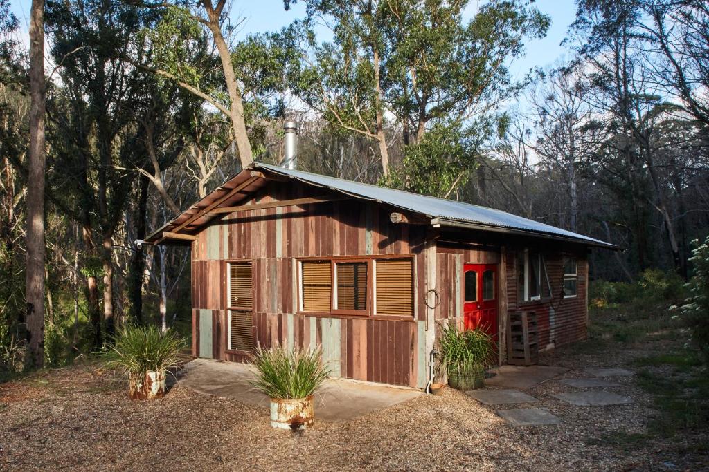 ReidsdaleMonga Mountain Retreat的一座带红色门的小木结构建筑