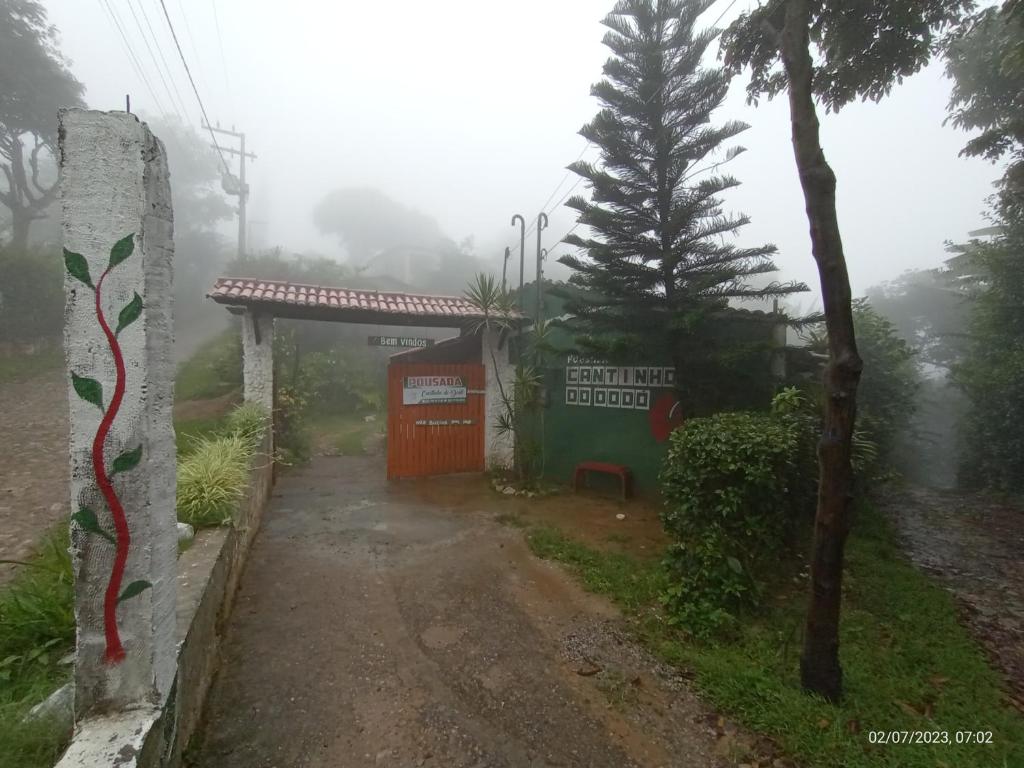 穆隆古Pousada Cantinho do Dodó的一条有楼房和树的迷雾路