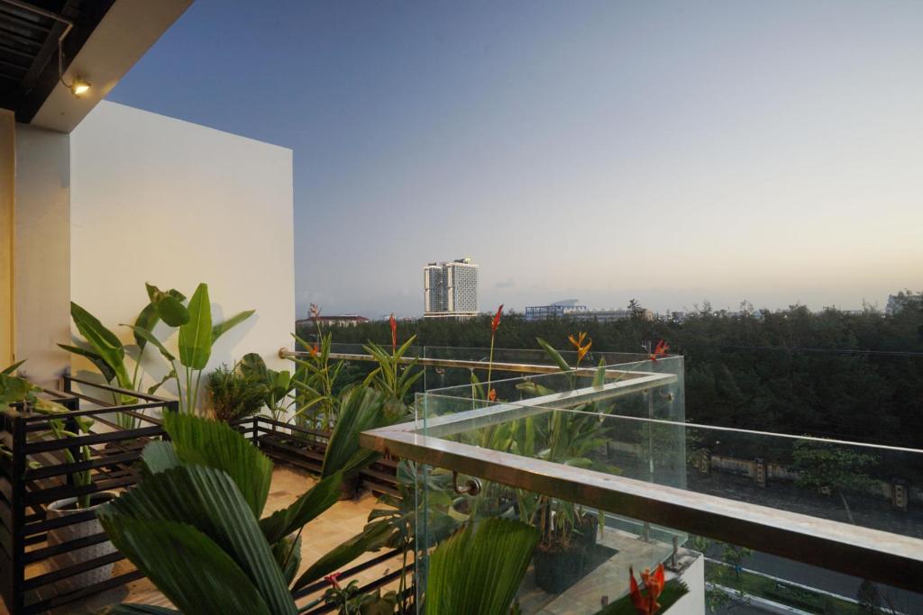 Liên Trì (4)Khách sạn gần biển Karina Phú Yên的一座带玻璃阳台的建筑,种植了植物