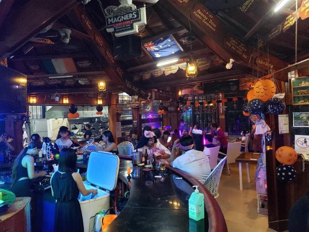 奥隆阿波PALM TREE RESORT AND RESTAURANT的一群人坐在餐厅酒吧里