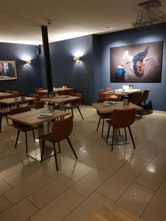 格罗瑙弗里茨酒店餐厅的用餐室配有木桌和椅子