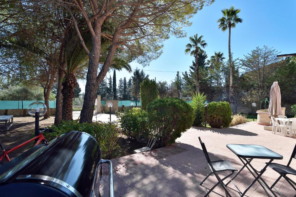 阿沃拉Villa Gioia Relais的庭院配有桌椅和棕榈树