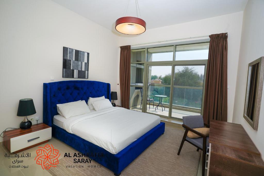 迪拜Alashrafia Saray 2BR apartment in Sport City的一间卧室配有一张床、一张书桌和一个窗户。