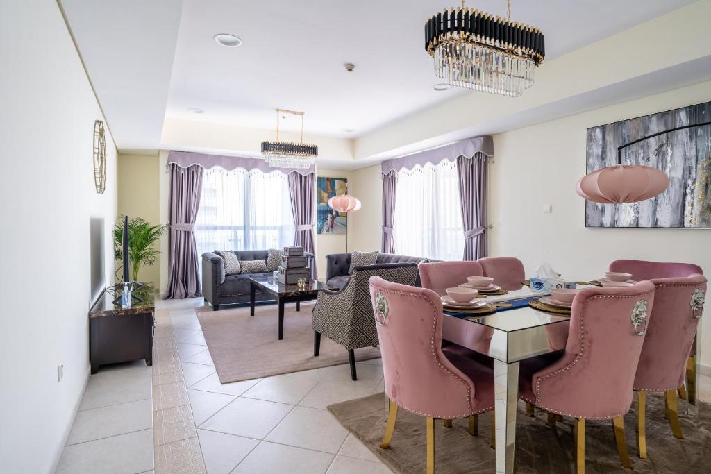 迪拜Veer Apartments - 82nd Floor Princess Tower - Palm View的客厅配有餐桌和粉红色椅子