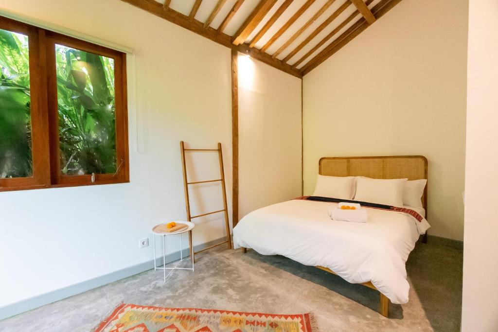 乌布Singgah di Ubud 2的一间卧室设有一张床和一个窗口