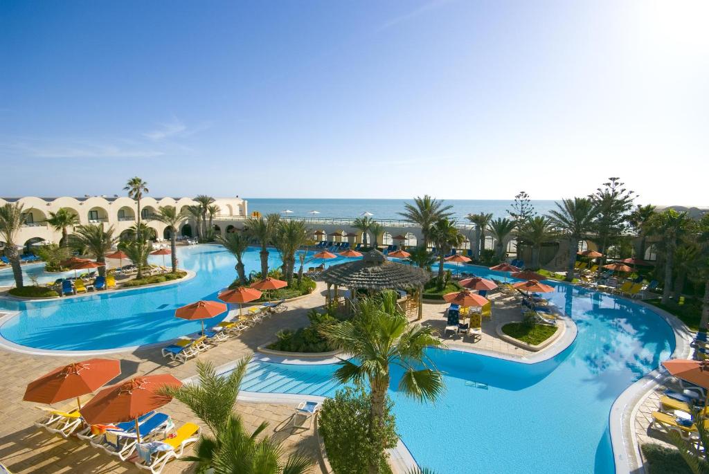 米多恩杰尔巴圣提多海滩酒店的享有带遮阳伞的度假村游泳池的空中景致