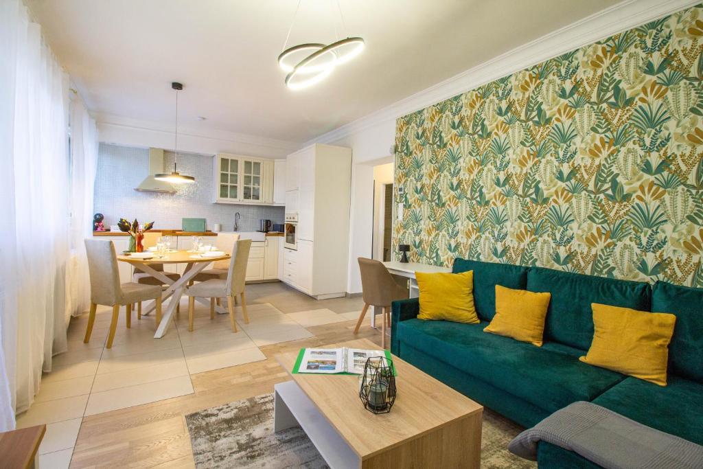布达佩斯Hillside Lodge的一间带绿色沙发的客厅和一间用餐室
