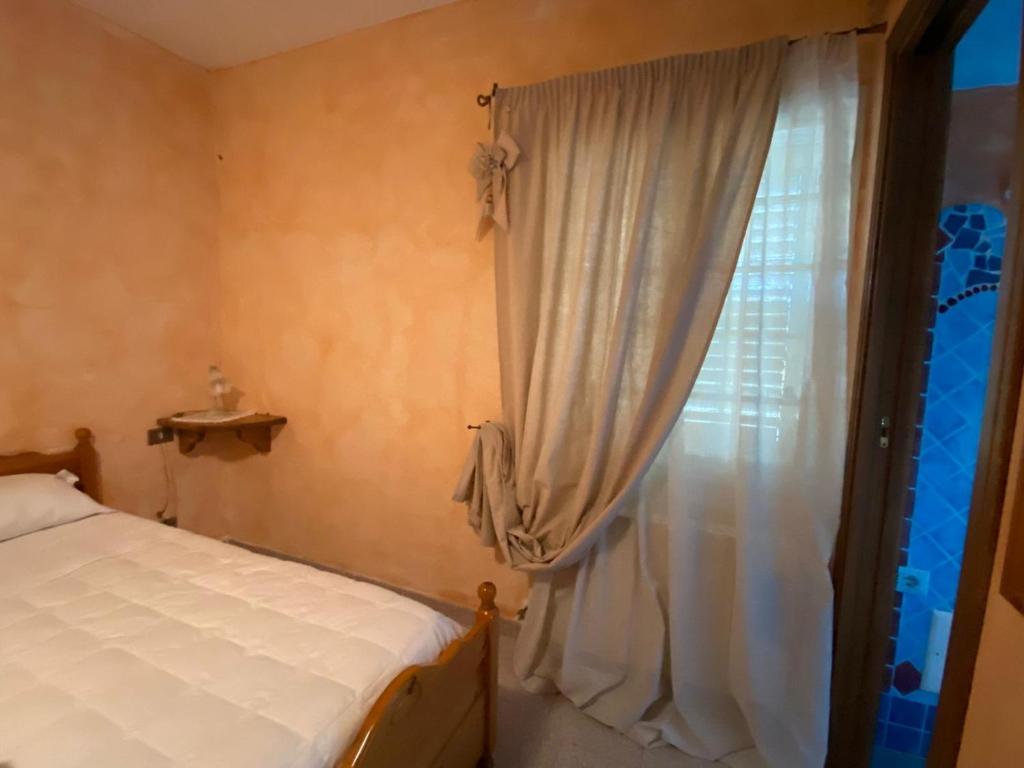 坎尼吉翁Bed and Breakfast Li Paduli Alvi的一间卧室设有一张床和一个窗口
