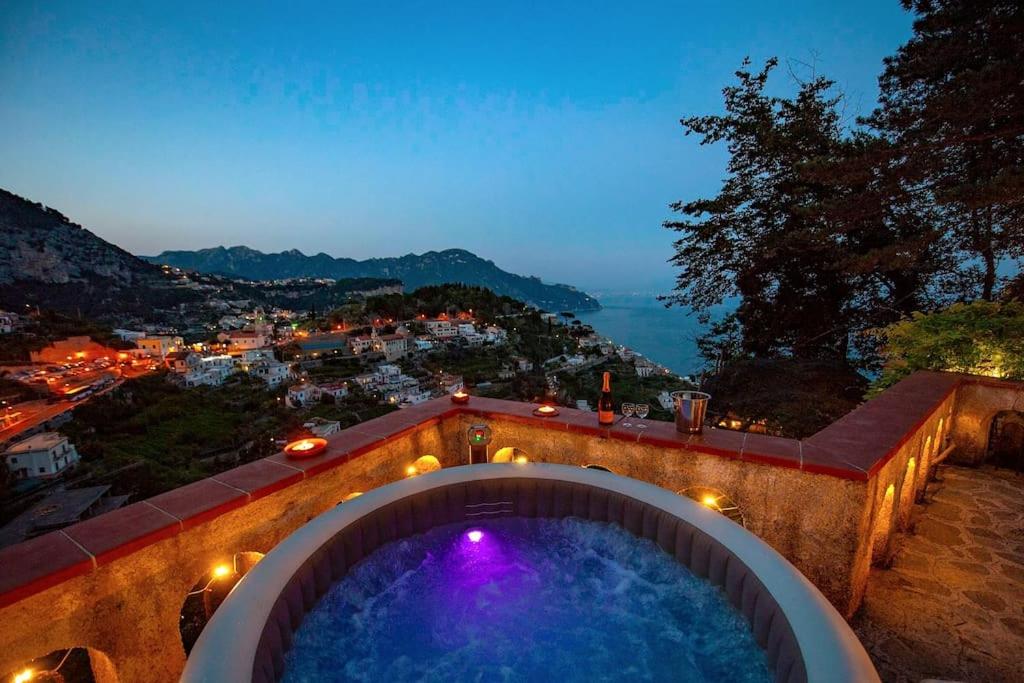 阿马尔菲Villa Nina Amalfi的浴缸,晚上可欣赏到城市美景