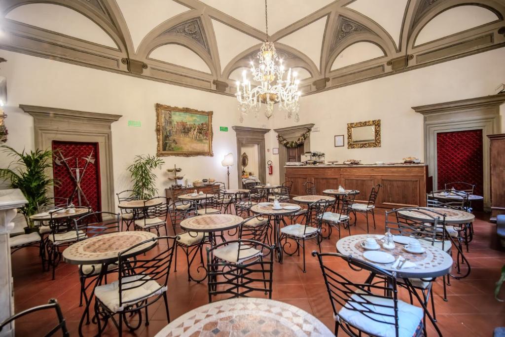 佛罗伦萨马尔泰利酒店的大型客房配有桌椅和吊灯。