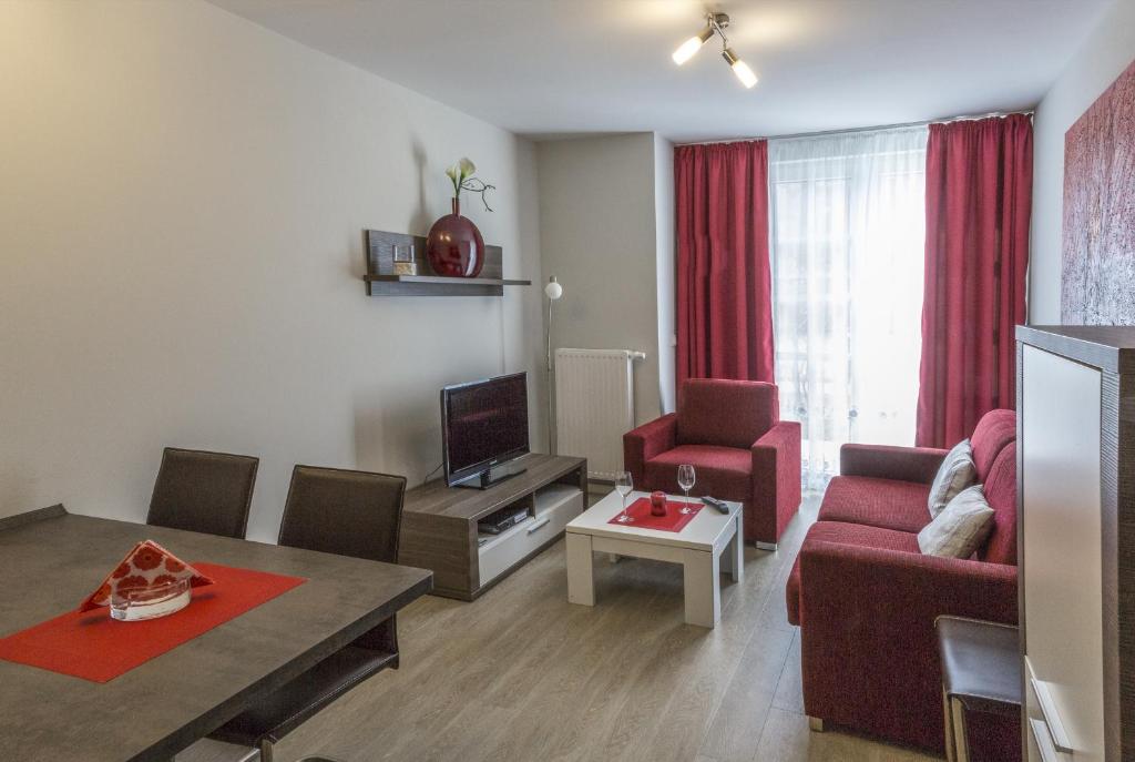巴尔姆Apartment Residenz am Balmer See Wohnung 44 mit Wellnessbereich的客厅配有红色的沙发和桌子
