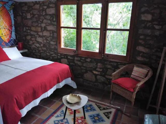 圣巴勃罗-德塞古列斯Hostal La vall的一间卧室配有一张床、一把椅子和窗户。
