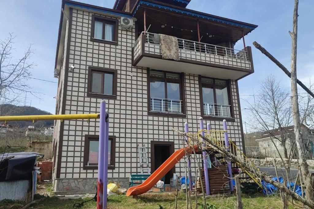 AraklıTrabzon Deniz Manzaralı villa的前面有游乐场的房子