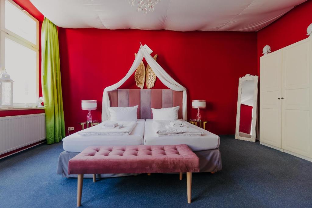 德累斯顿拉拉鲁德累斯顿旅舍的红色的房间,设有两张床和红色的墙壁