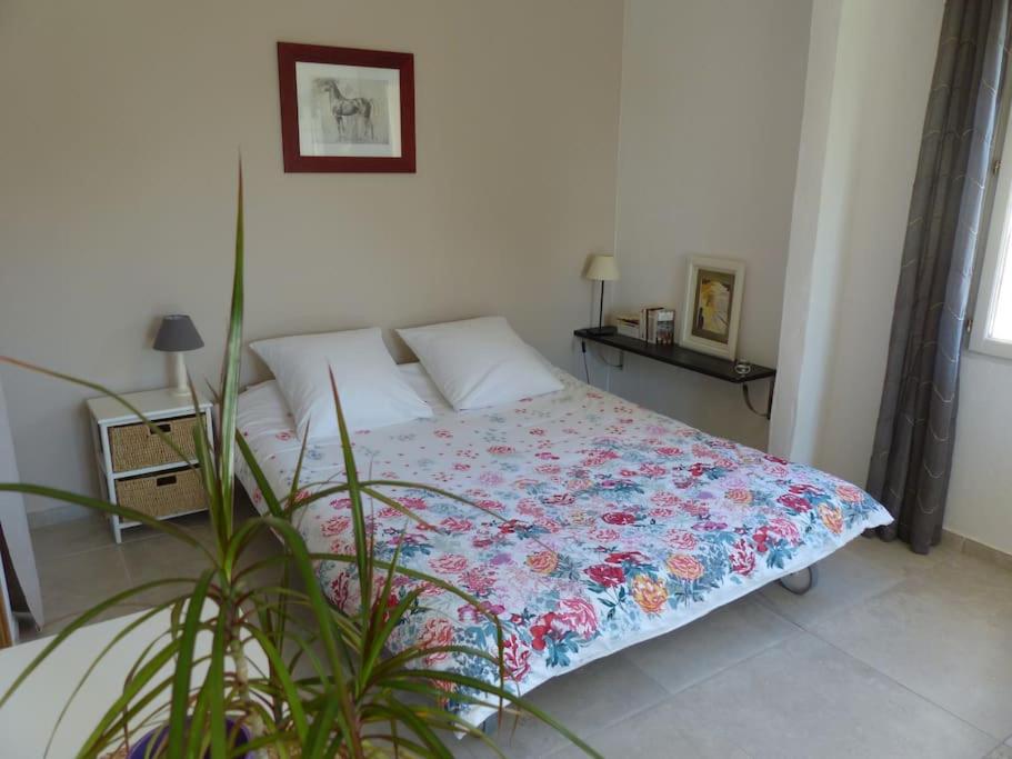 佩尔蒂Campagne de Saint Clair的一间卧室配有一张带花卉被子的床