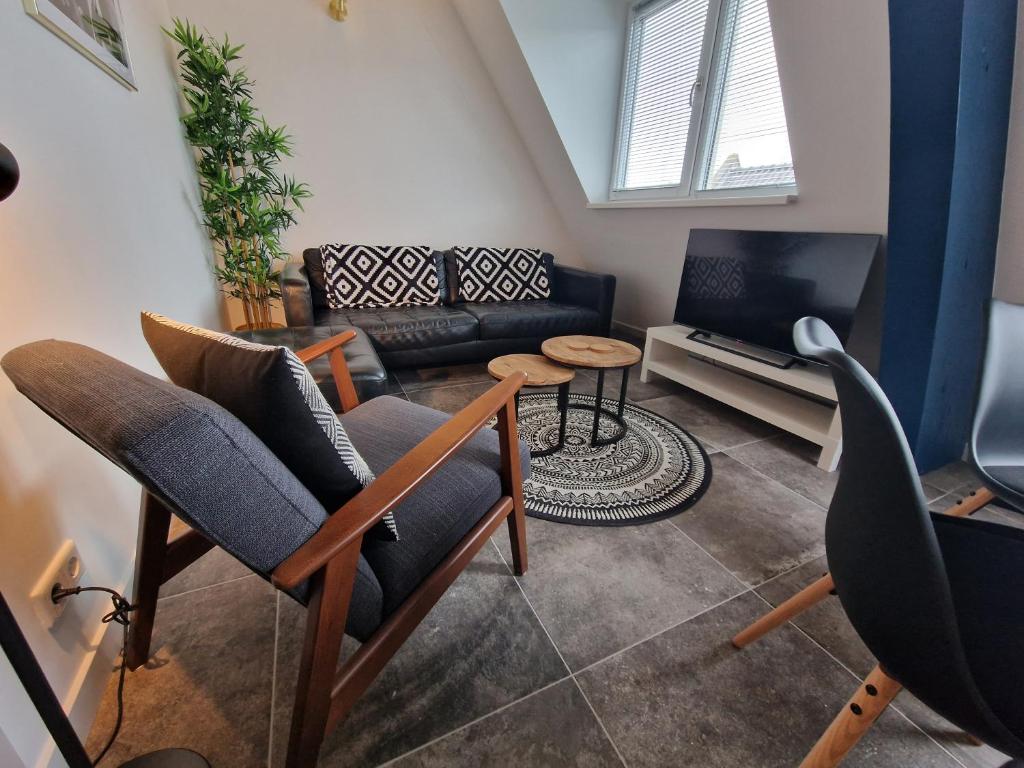 弗利辛恩Woonhotel Petruskerk的客厅配有两把椅子和一张沙发