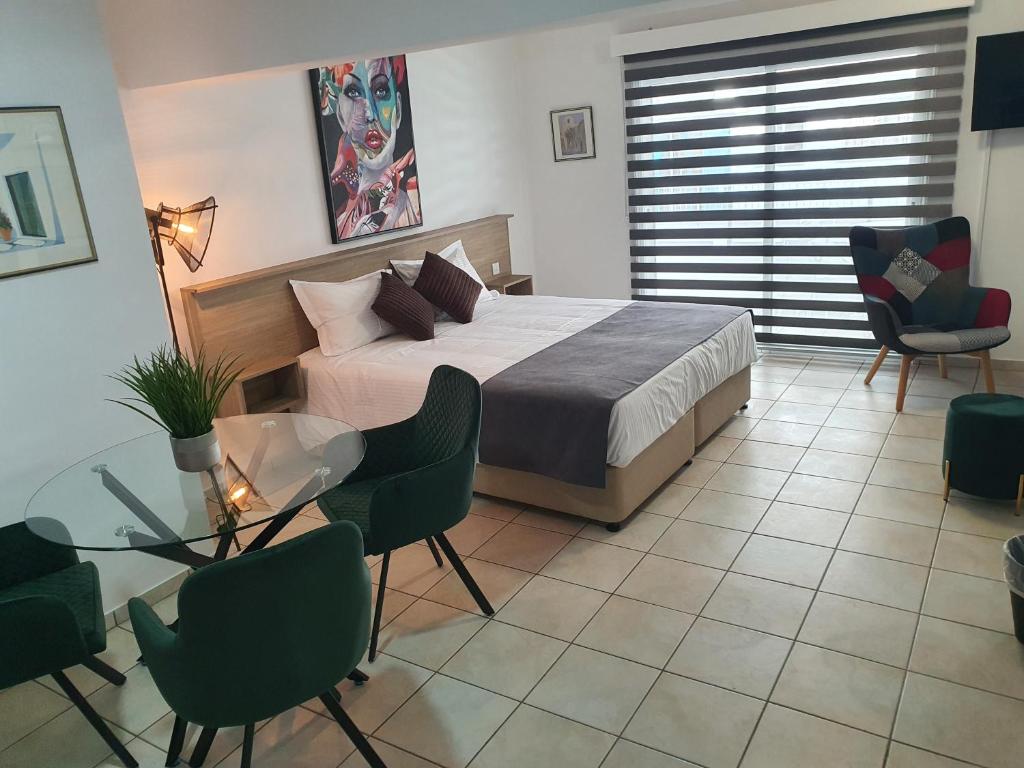 拉纳卡Larnaca Bay Suites的卧室配有一张床和一张桌子及椅子