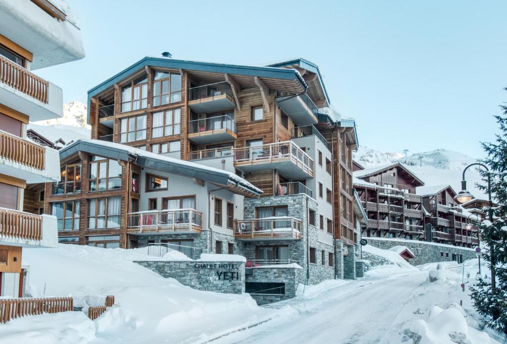 蒂涅Chalet Hotel Yeti的大楼前有雪覆盖的街道